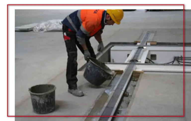 robotnik i narzędzie do wygładzania betonu